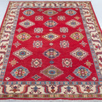Full view from a low angle of red & blue Kazak-inspired wool rug 24995.