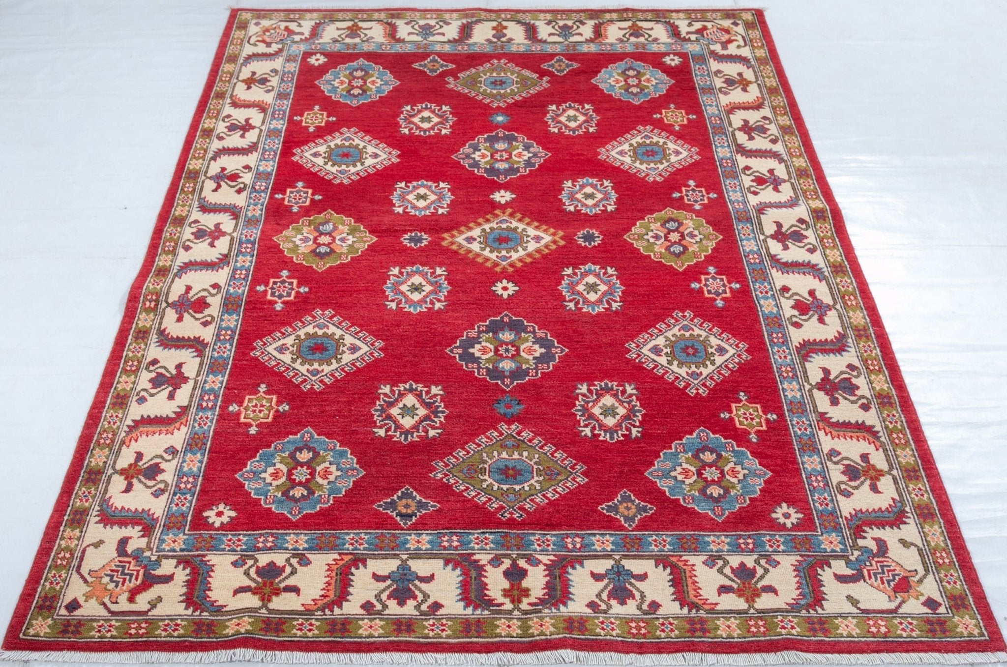 Full view from a low angle of red & blue Kazak-inspired wool rug 24995.