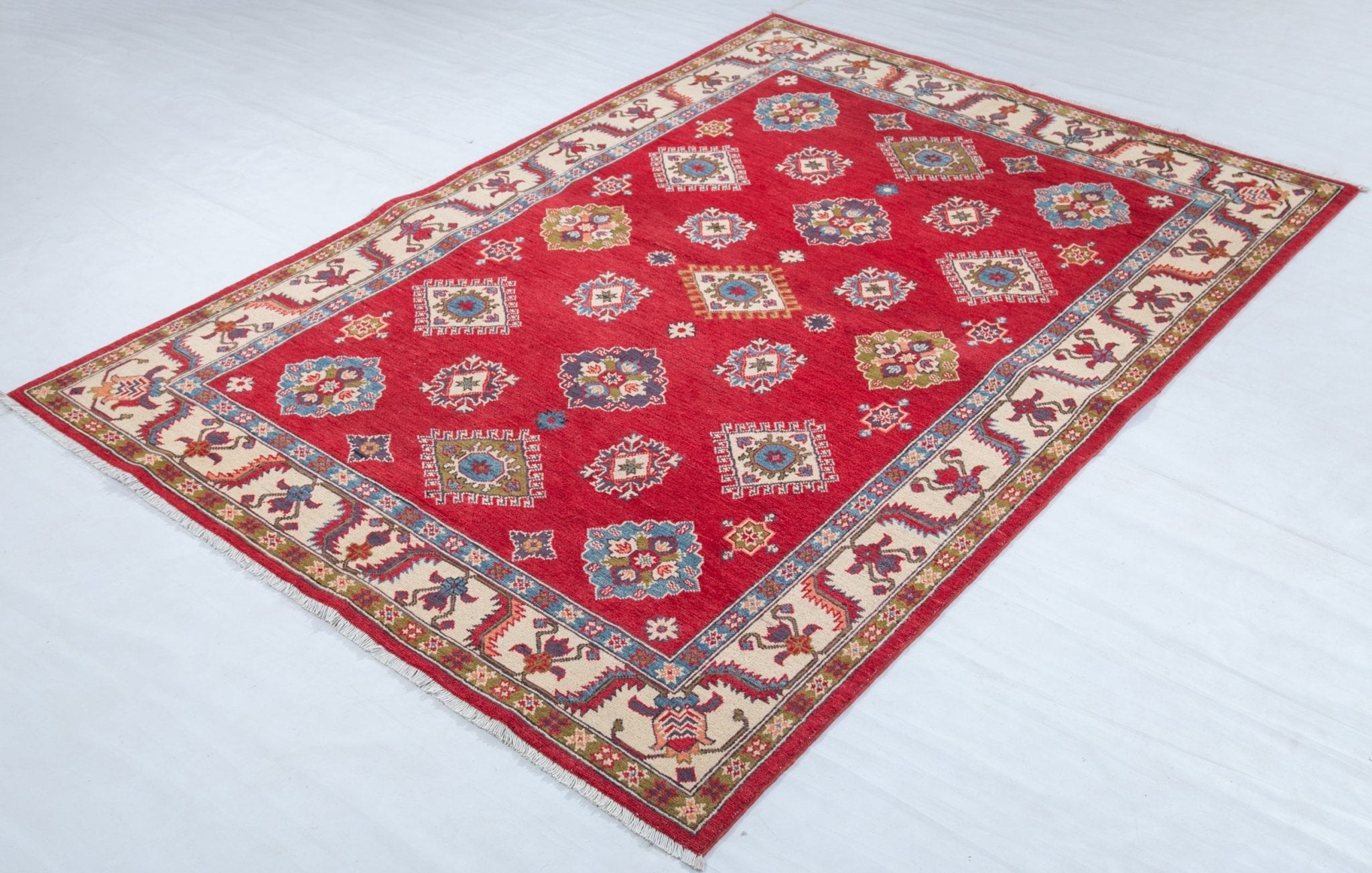 Full view at an angle of red & blue Kazak-inspired wool rug 24995.