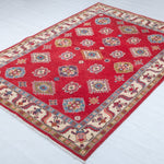 Full view at an angle of red & blue Kazak-inspired wool rug 24995.