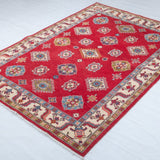 Full view at an angle of red & blue Kazak-inspired wool rug 24995.
