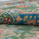 Folded edge and wool pile of green & blue Kazak-inspired wool rug 29637.
