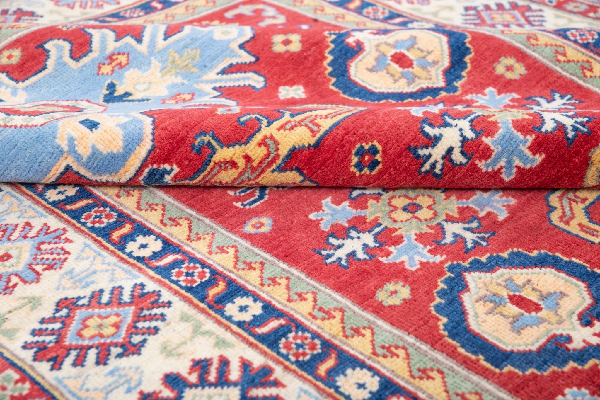 Folded edge and wool pile of red & ivory Kazak-inspired wool rug 21989.