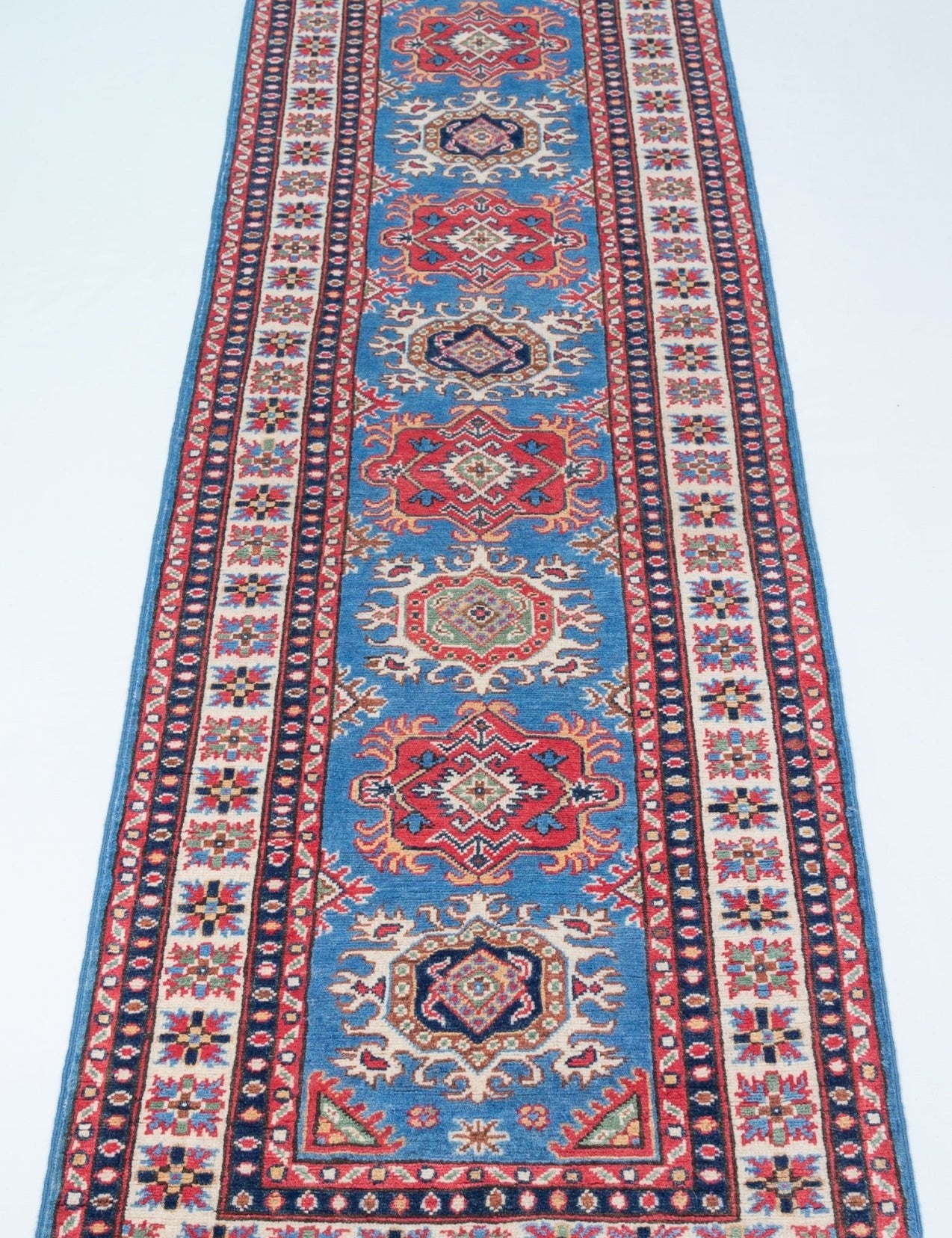 Full view from a low angle of blue & red Kazak-inspired wool runner 29653.