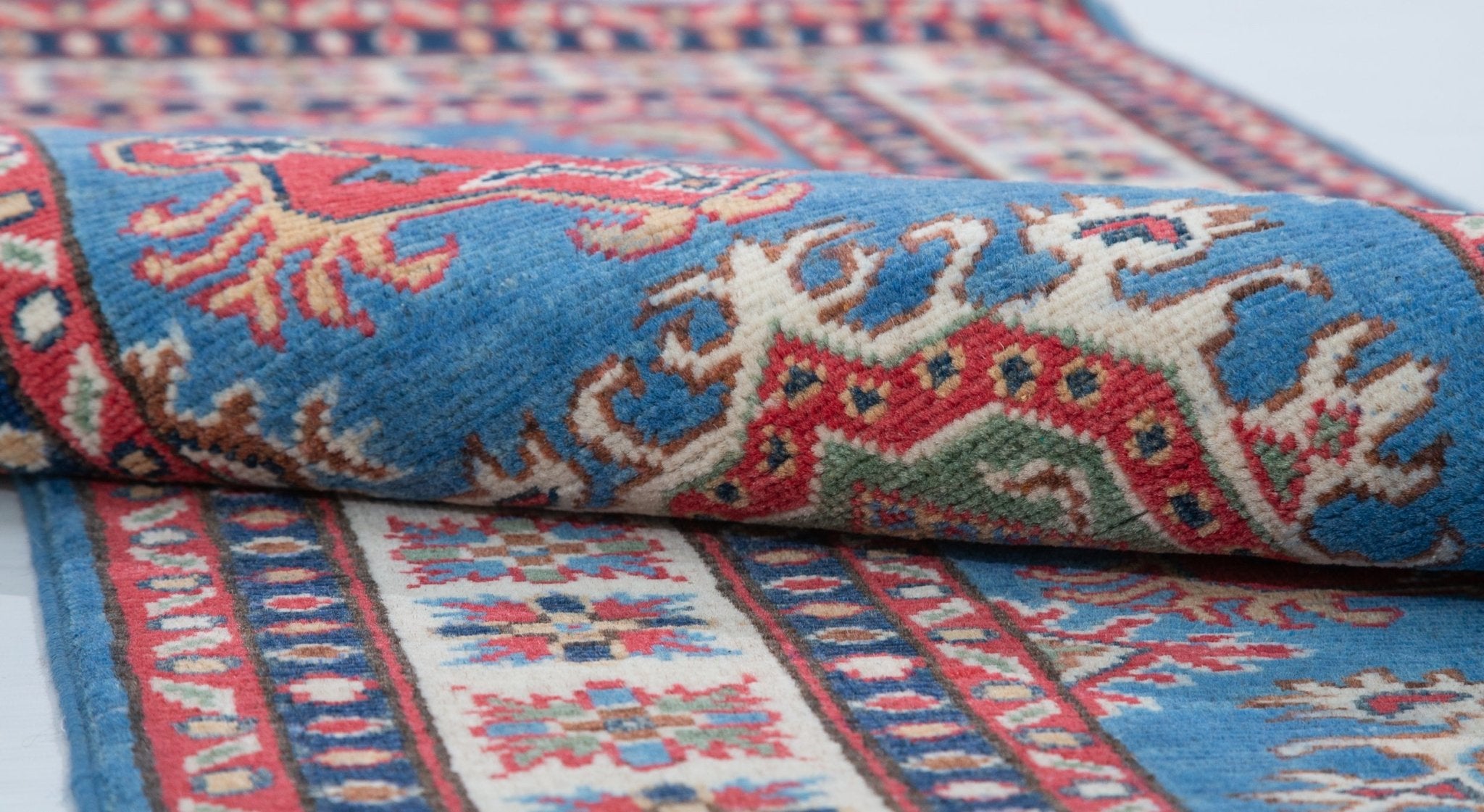 Folded edge and wool pile of blue & red Kazak-inspired wool runner 29653.