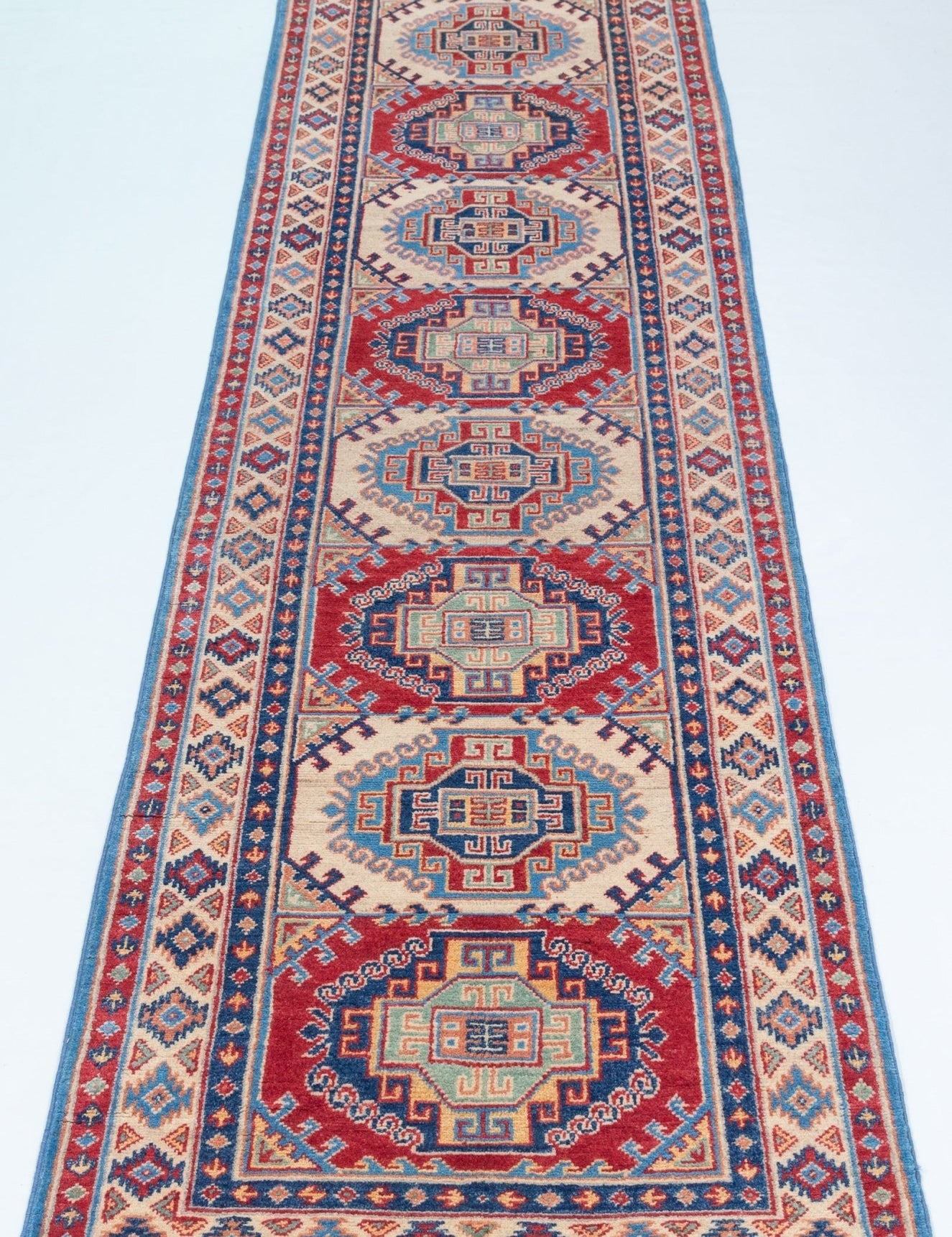 Full view from a low angle of blue & red Kazak-inspired wool runner 29656.