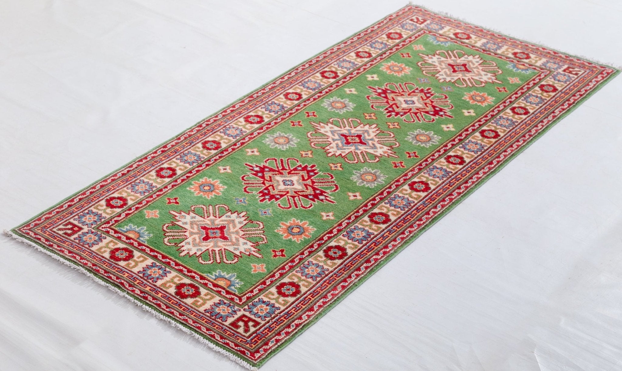 Full view at an angle of green & red Kazak-inspired wool runner 29353.