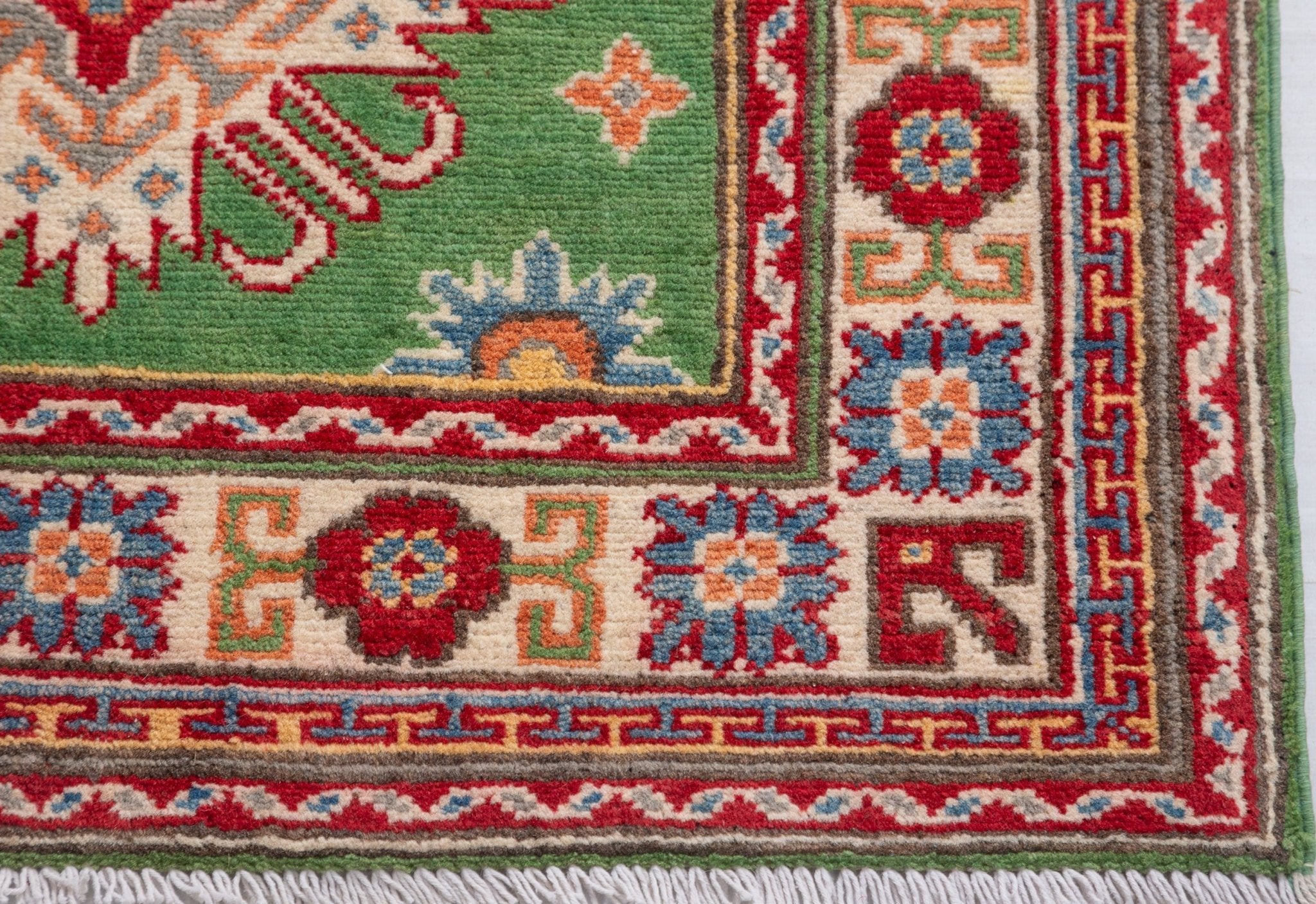 Border and edge detail of green & red Kazak-inspired wool runner 29353.