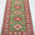 Full view from a low angle of green & red Kazak-inspired wool runner 29353.