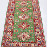 Full view from a low angle of green & red Kazak-inspired wool runner 29353.