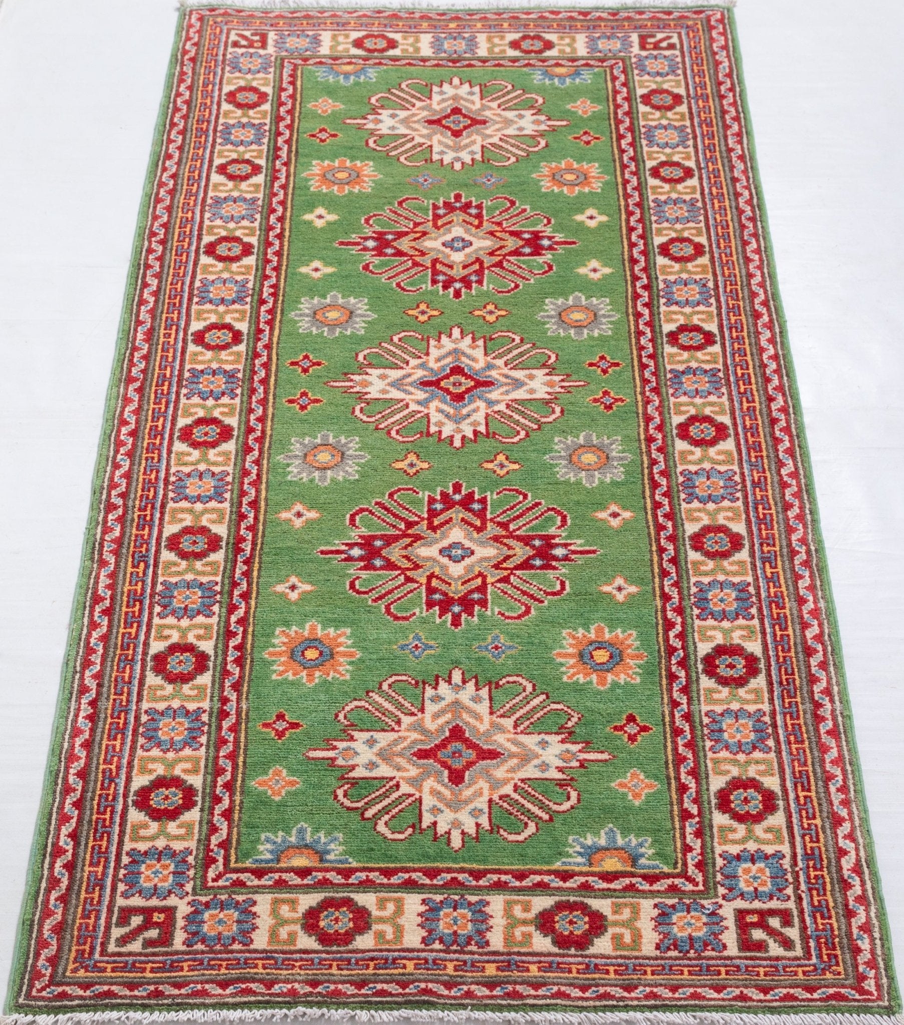 Full view from a low angle of green & red Kazak-inspired wool runner 29353.
