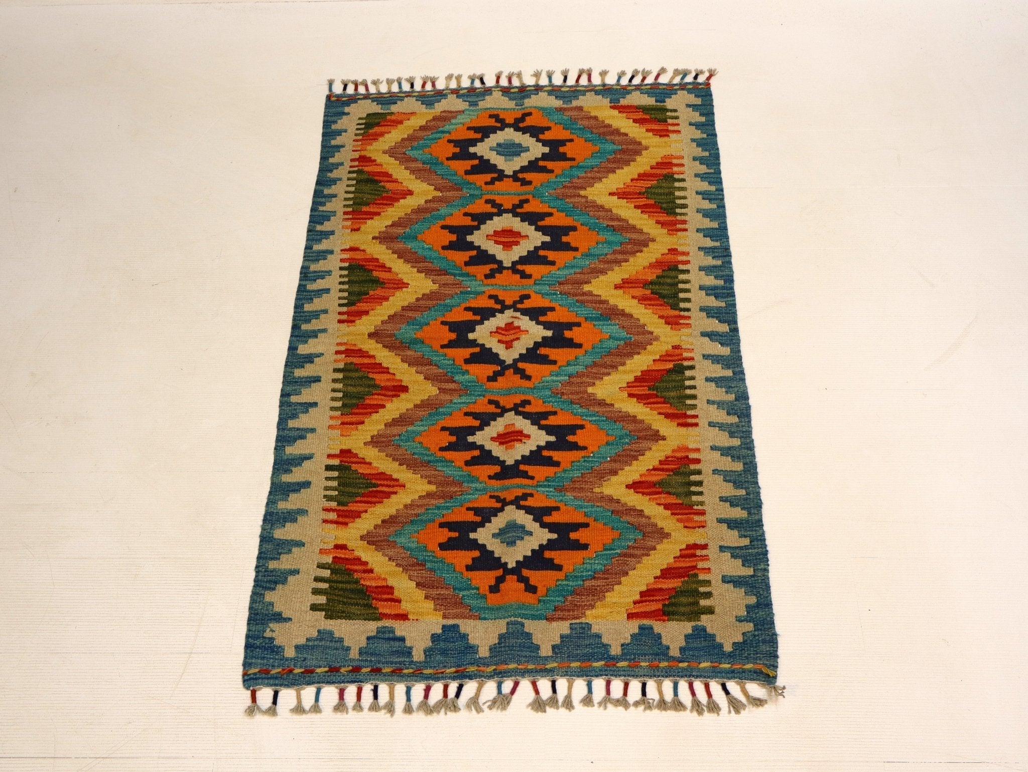 Afghan kilim rug with teal, orange, yellow and navy diamond motifs