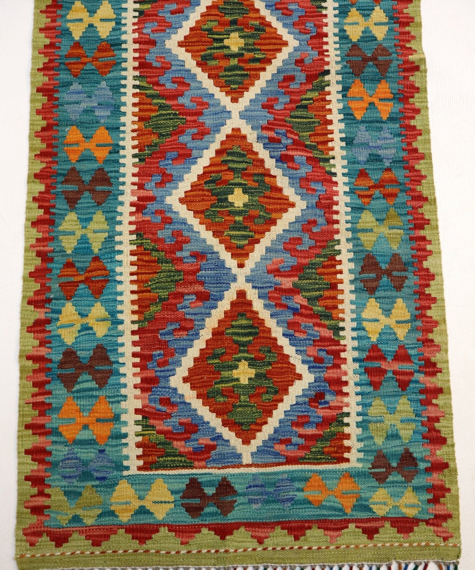 Afghan kilim rug with symmetrical diamond pattern, multicolor stripes, and fringed ends