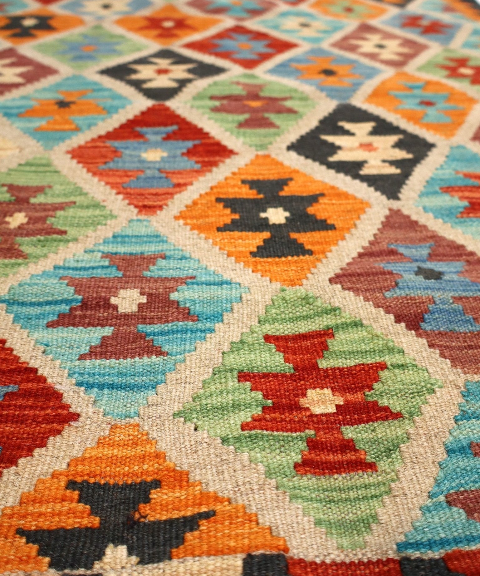 Geometric kilim rug with multicolor diamond motifs on a light cream background