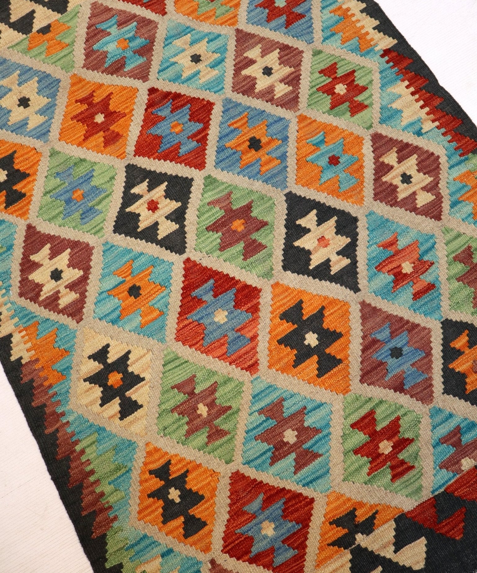 Multicolor kilim rug with repeating diamond pattern and dark border