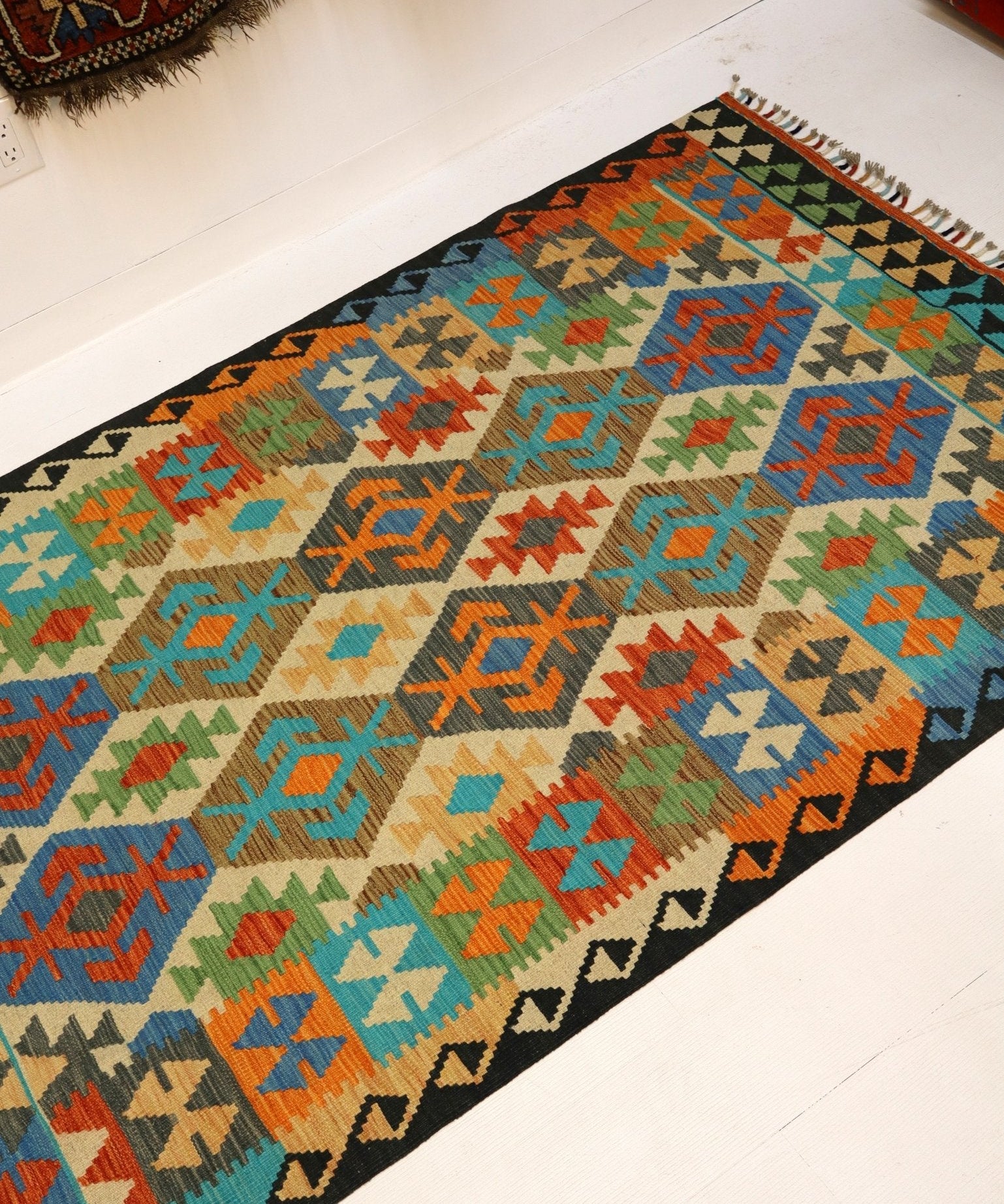 Flat-kite view of multicolor kilim rug with geometric design and short tassel fringe