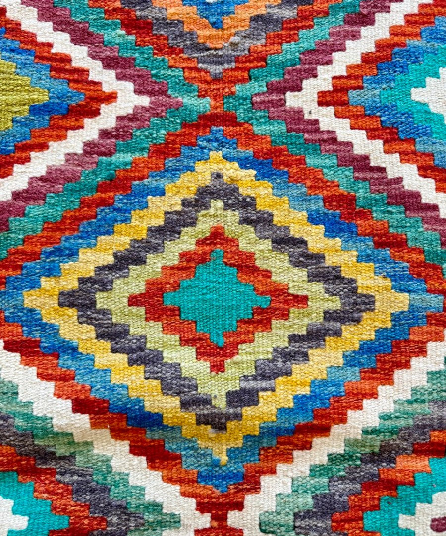 Close-up kilim rug weave with multicolor diamond motifs and zigzag bands