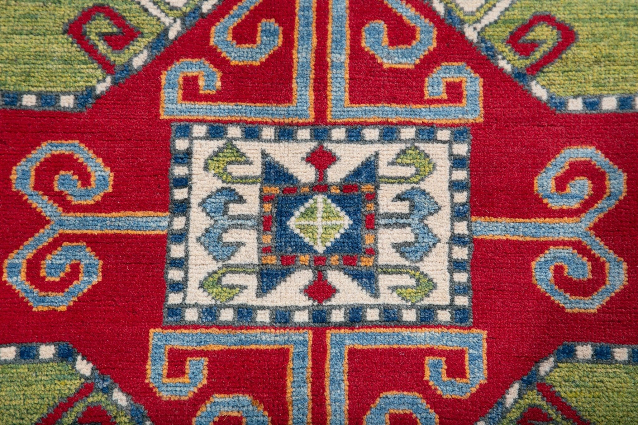 Pattern detail of red & green Kazak-inspired wool rug 24948.
