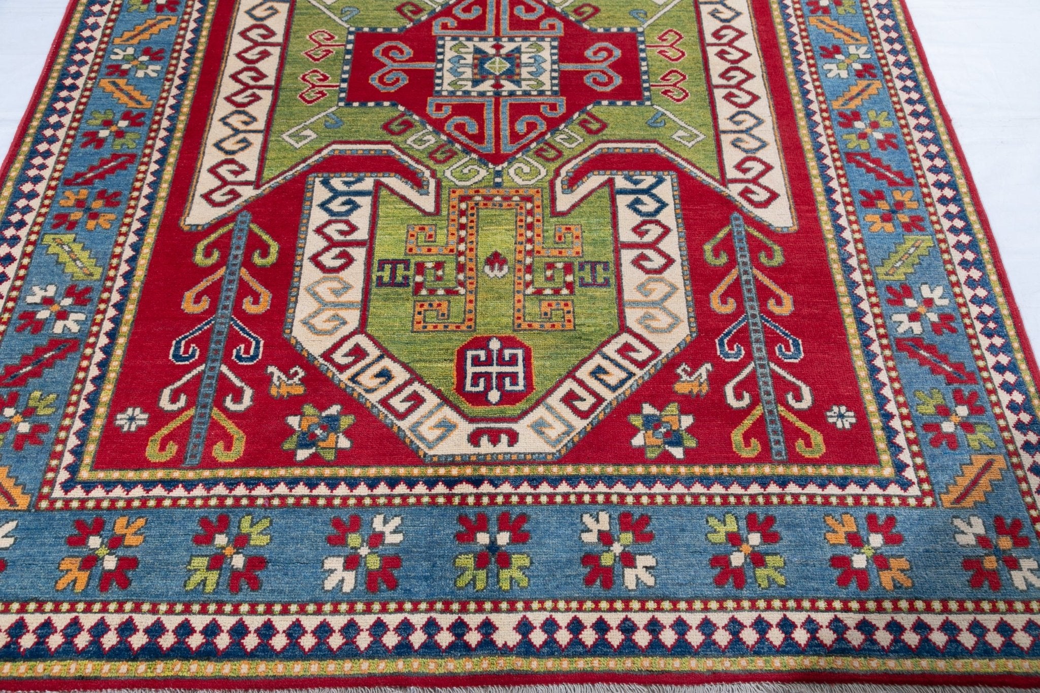 Border and edge detail of red & green Kazak-inspired wool rug 24948.