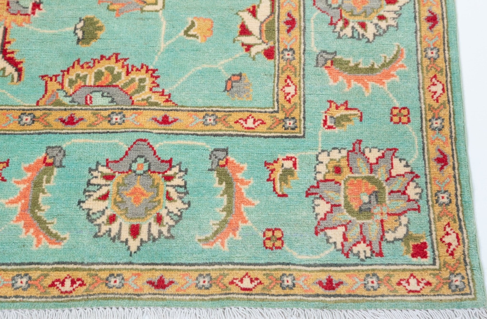 Border and edge detail of turquoise & red Kazak-inspired wool rug 29664.