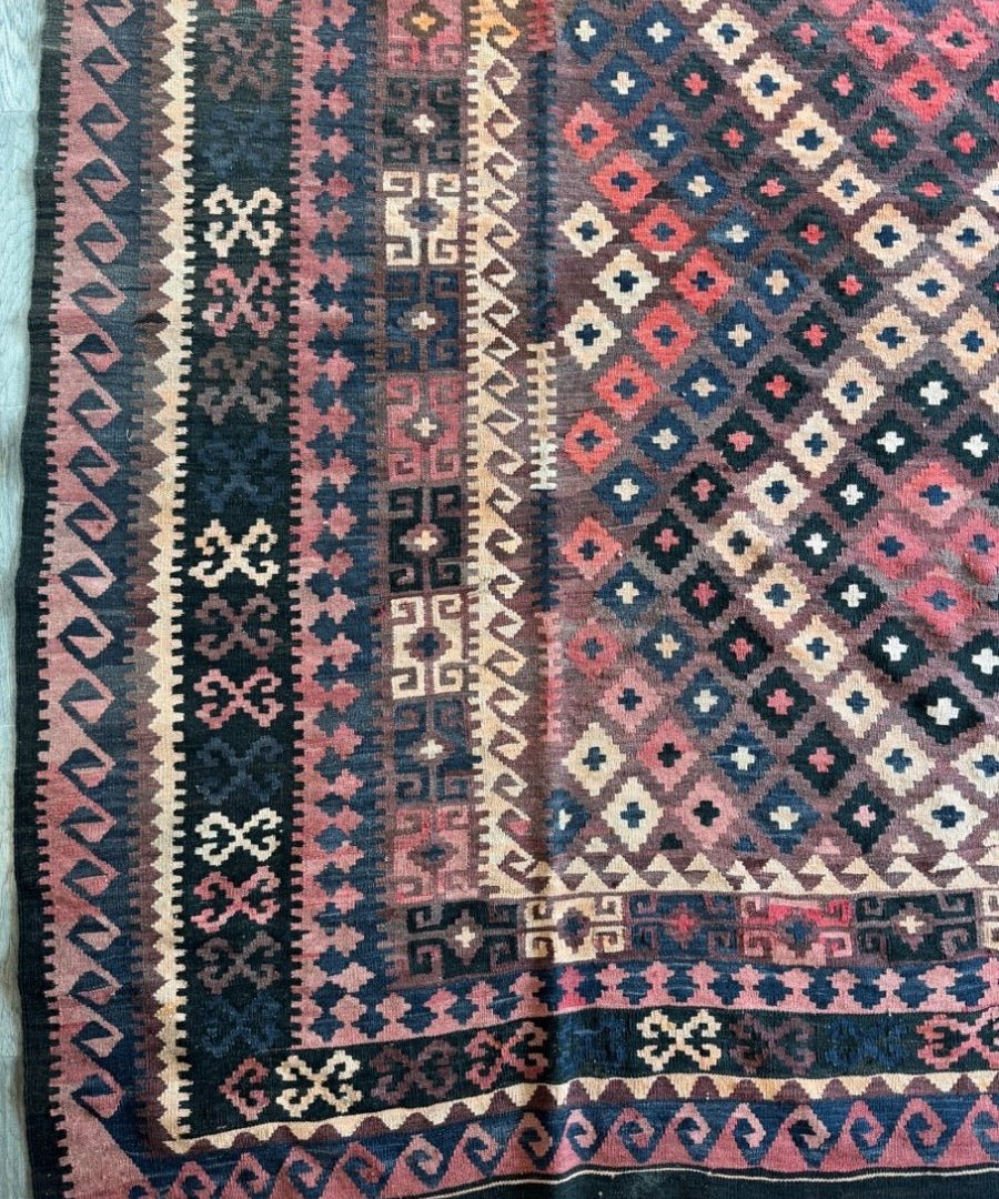 Geometric Afghan rug with multicolor diamond medallions and dark blue border, fringed edge