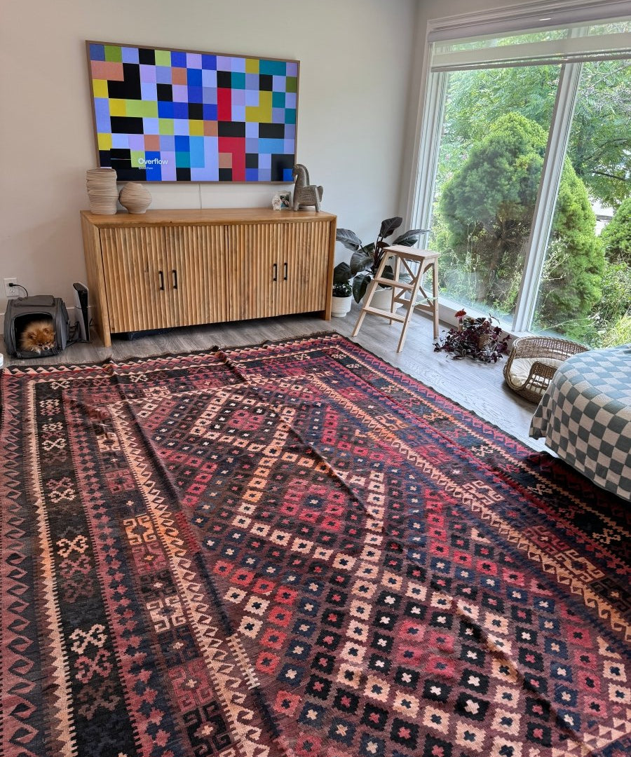 Geometric area rug with red ground, navy accents, and multicolor diamond patterns