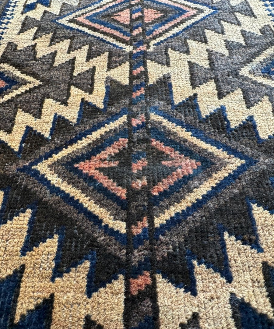 Antique Baluch bag face rug close-up with blue, cream, and red diamond-and-chevron pattern