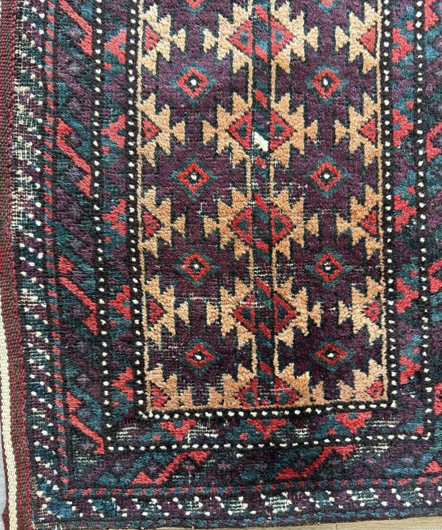 Antique Baluch bag face rug with geometric diamond motifs and teal red border