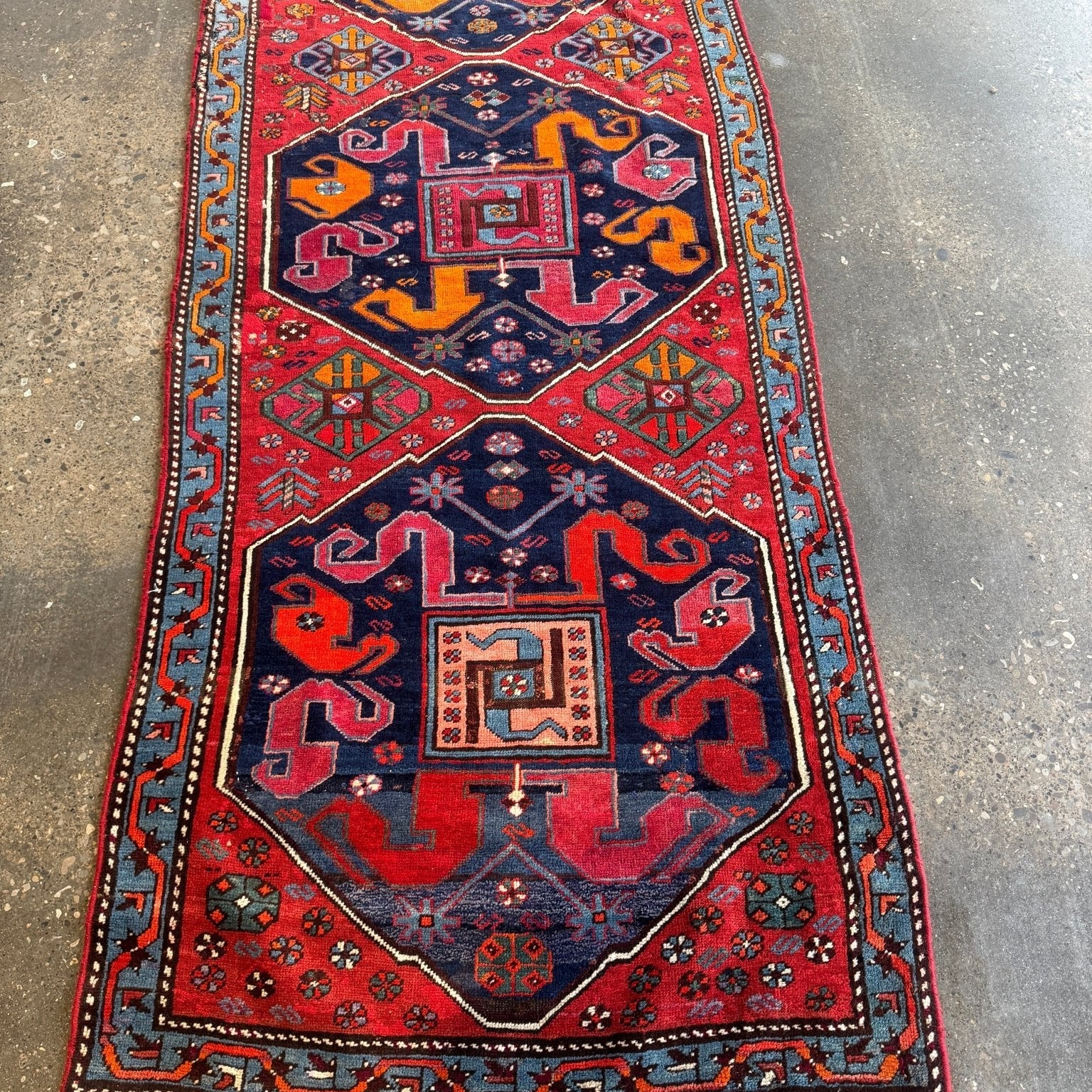 Full Karabagh rug runner with red, navy, and orange medallions and fringed ends.