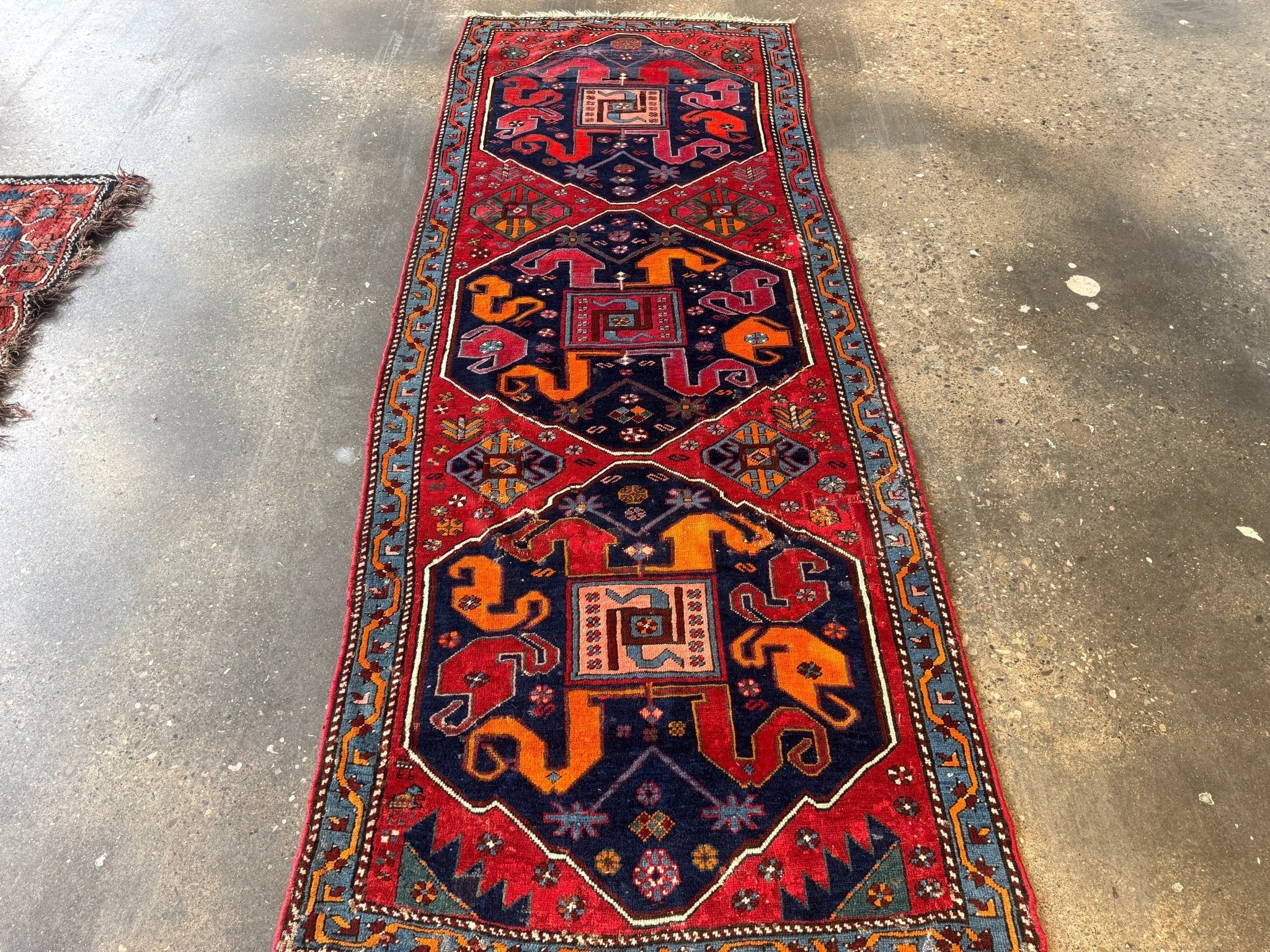 Full Karabagh rug runner with red field, navy medallion, and blue accents.