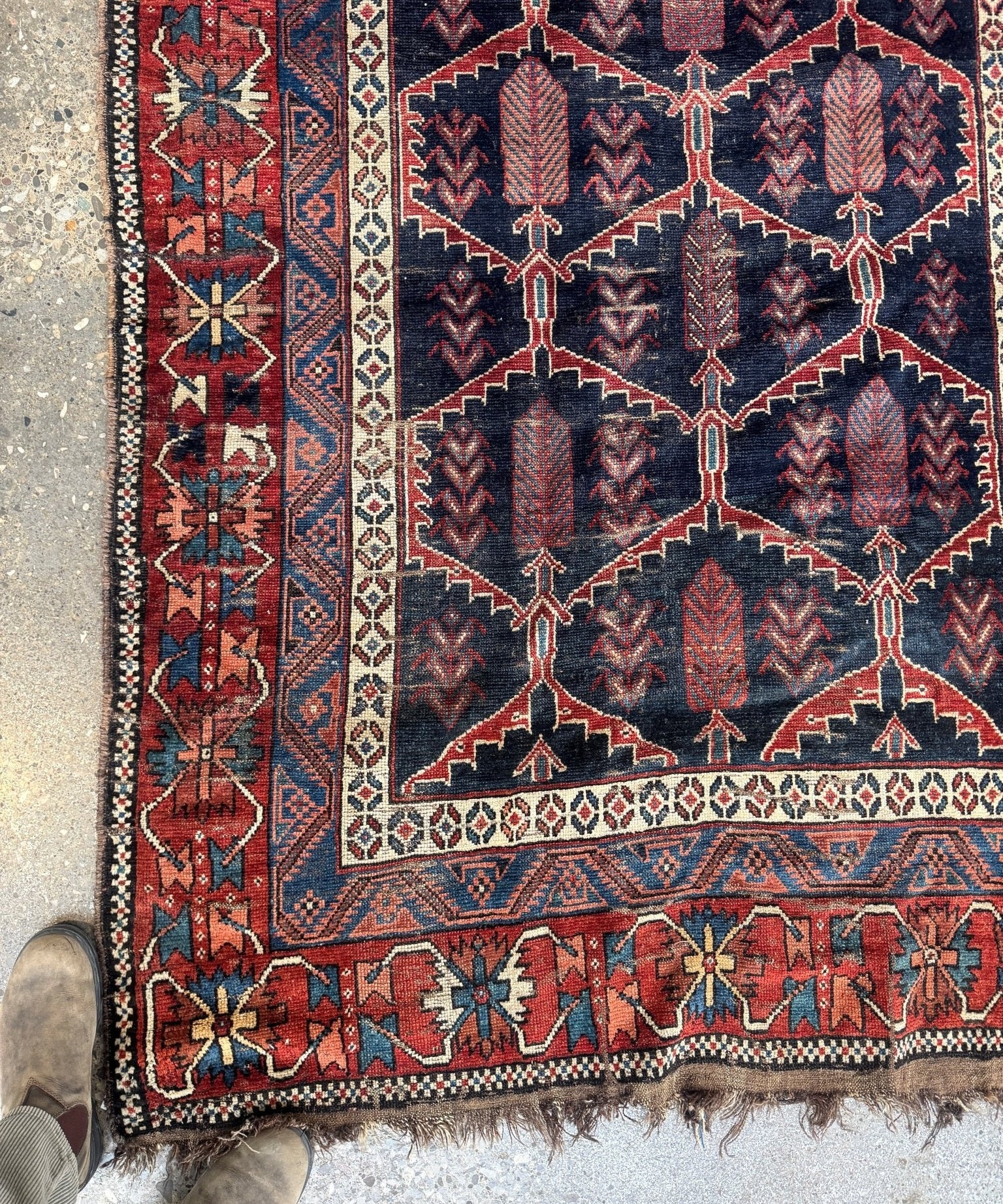 Antique Persian Bakhtiari rug detail showing navy and red rosette and chain patterns.