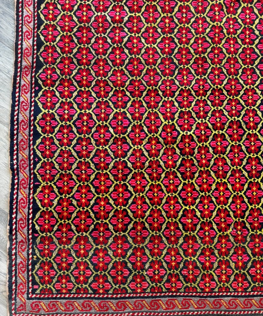 Persian-style runner rug with red field, navy background, and floral diamond motifs
