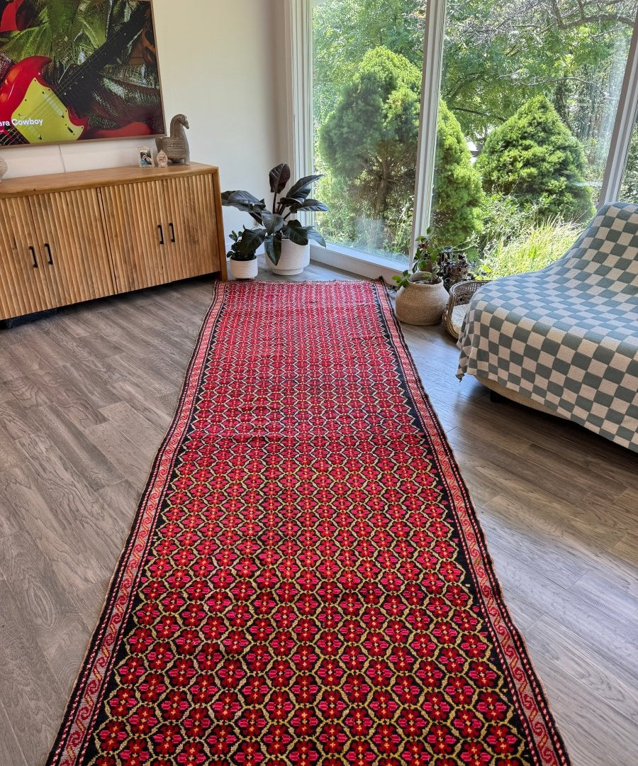 Red Persian-style runner rug with navy border and repeating floral medallion pattern