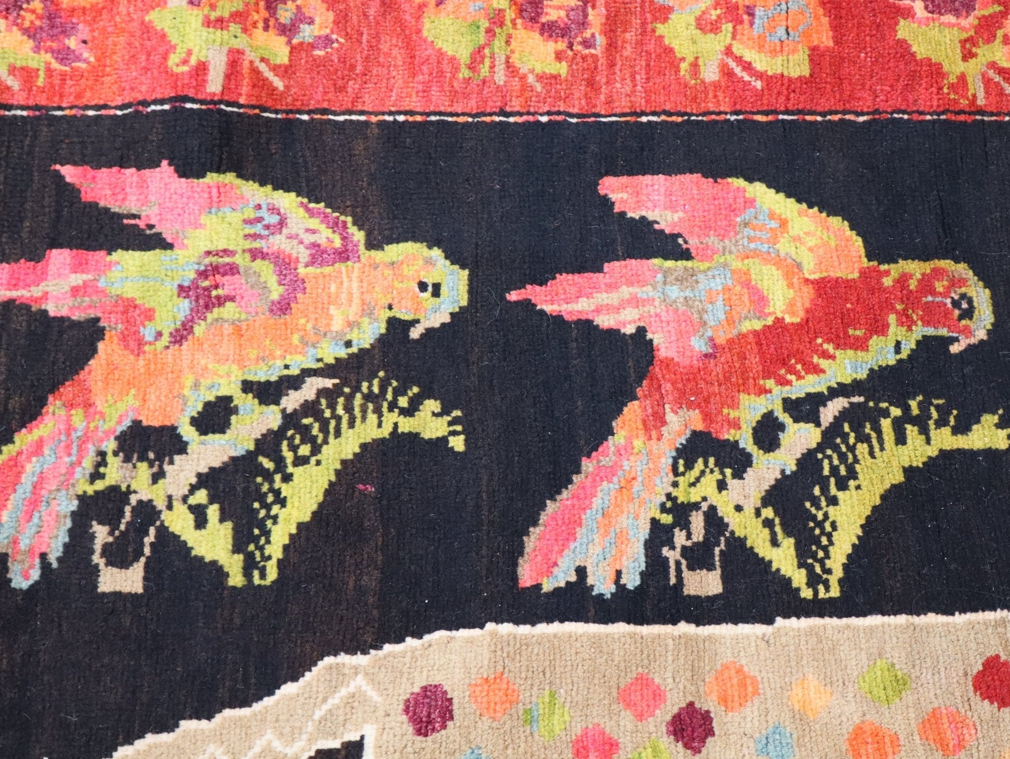 Rug corner detail with birdlike animals, bright pink and orange accents