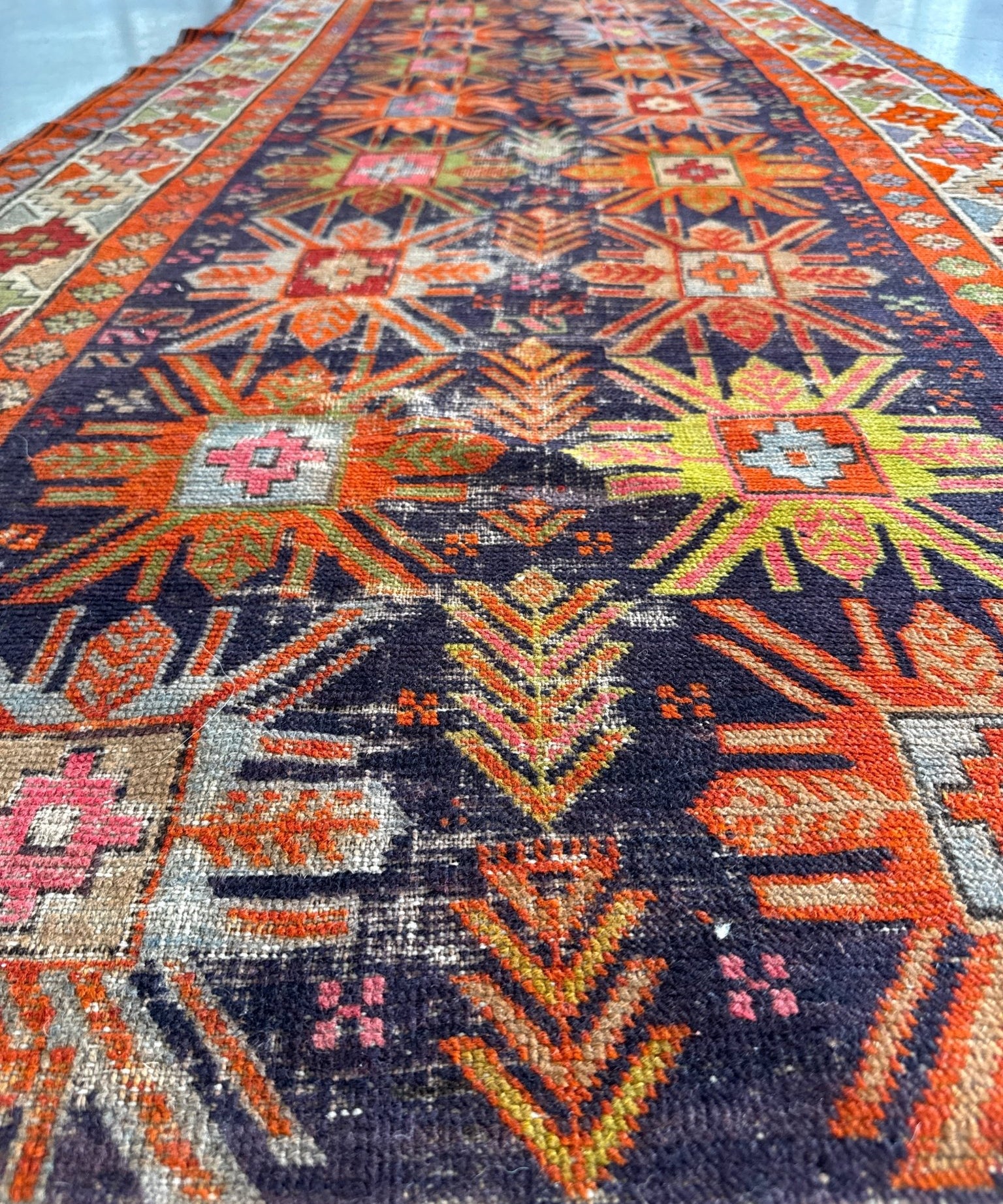 Multicolor Kazak runner rug with geometric medallion and repeating motifs