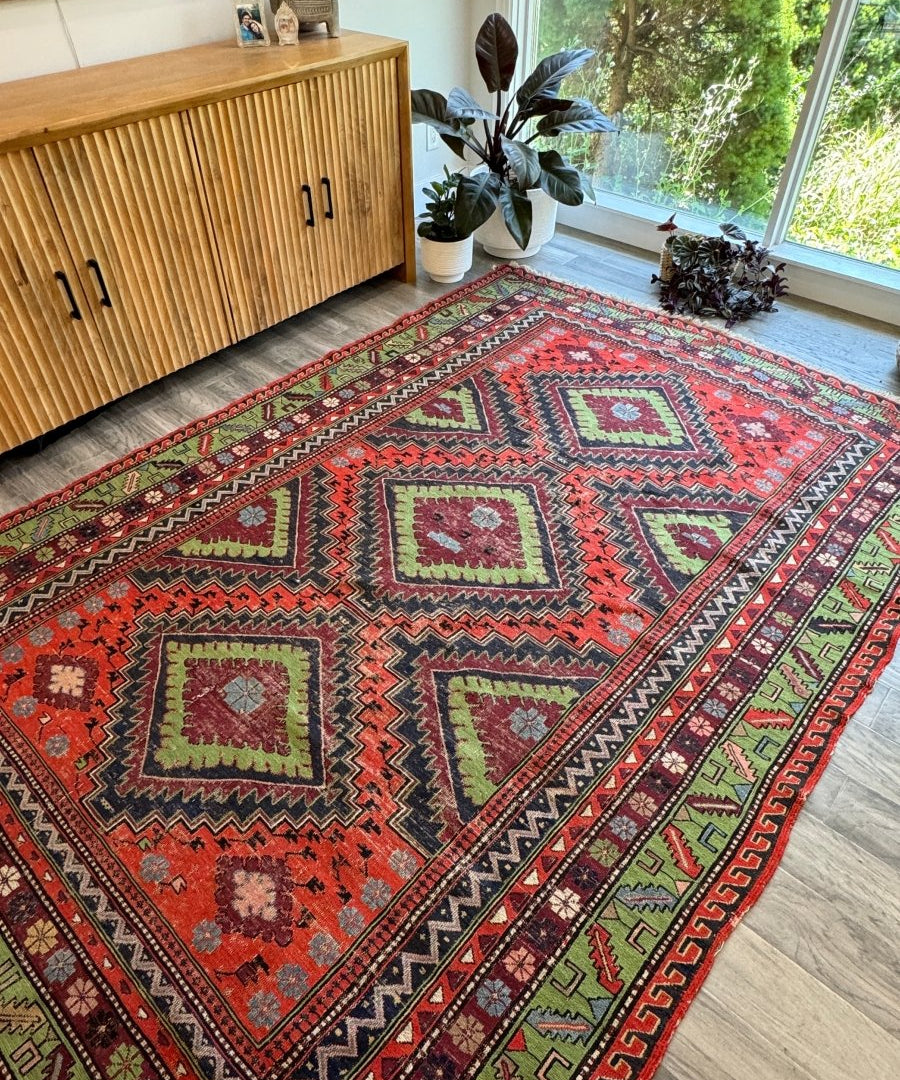 Soumak rug with red center medallions, green corner motifs, zigzag border and short fringe