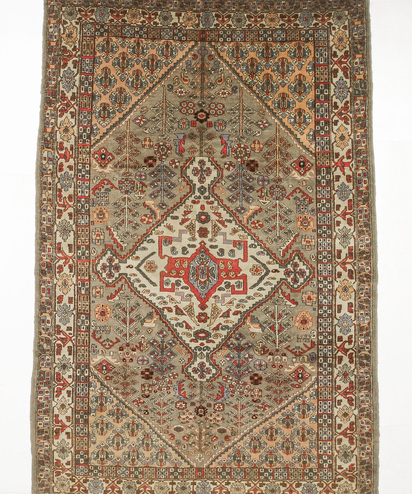Oriental rug flat against white background, beige field with red center panel and blue accents