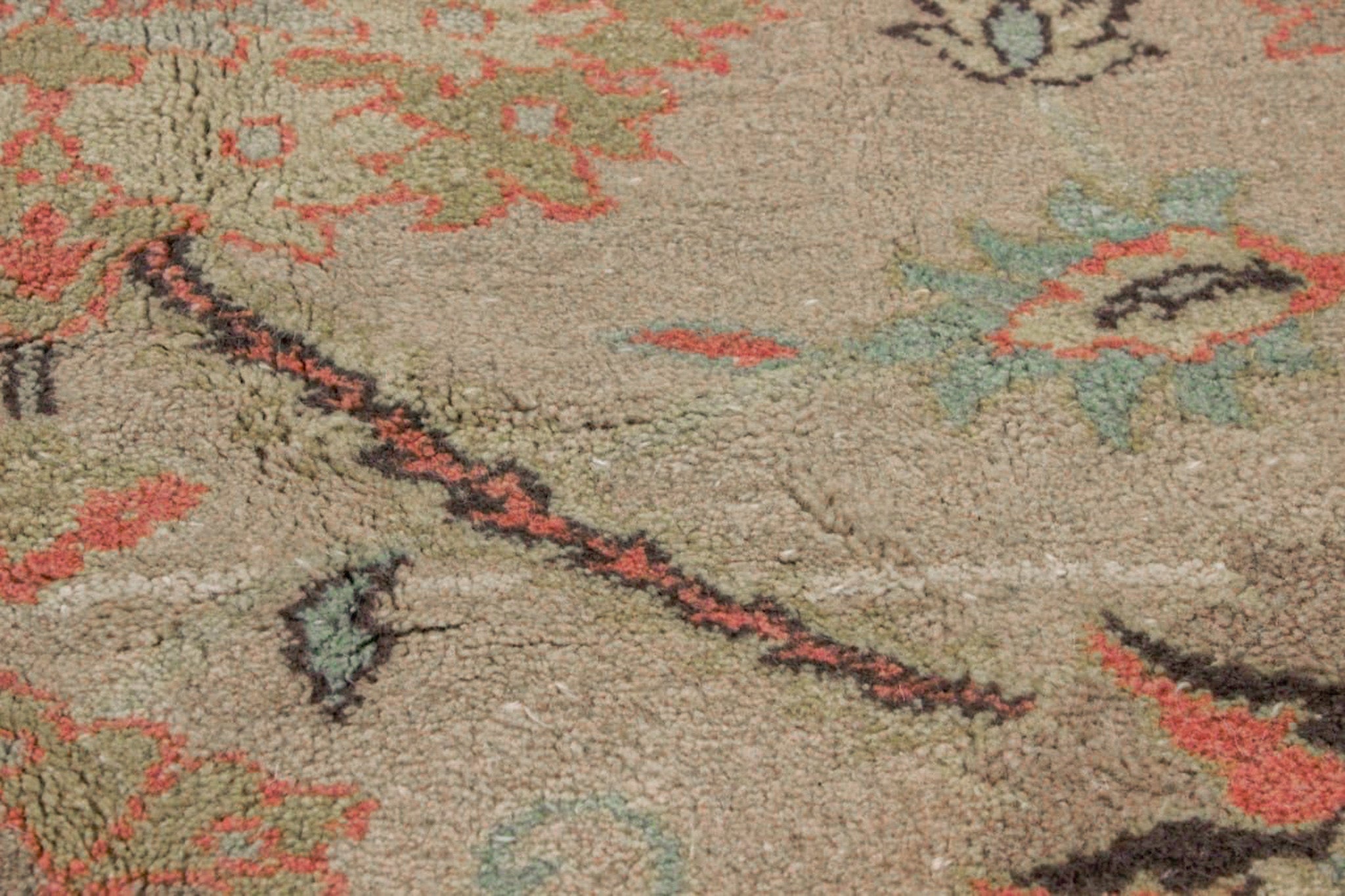 Close-up of Sultanabad rug pile with tan field, coral stripe, teal accents, knot pattern
