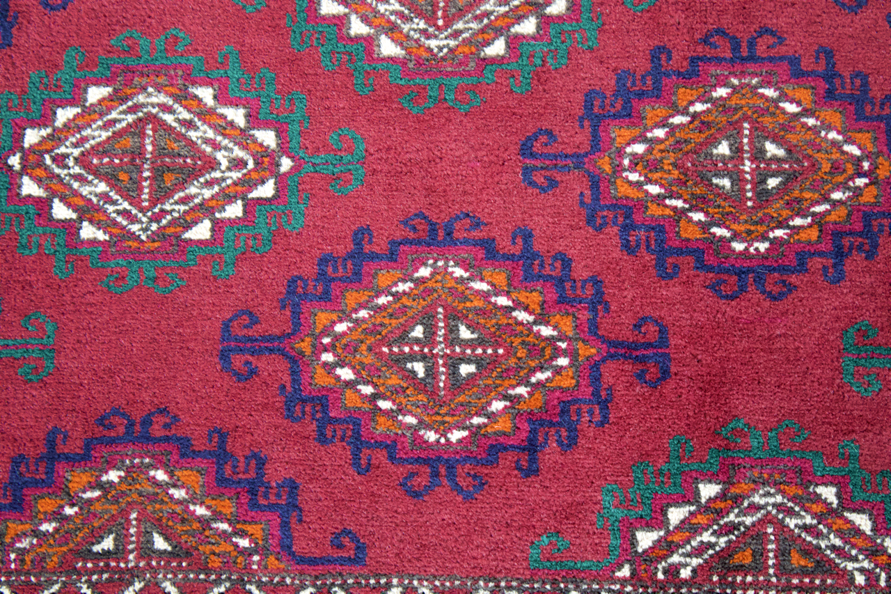 Blue and burgundy Bukhara rug with diamond medallions and small teal accents