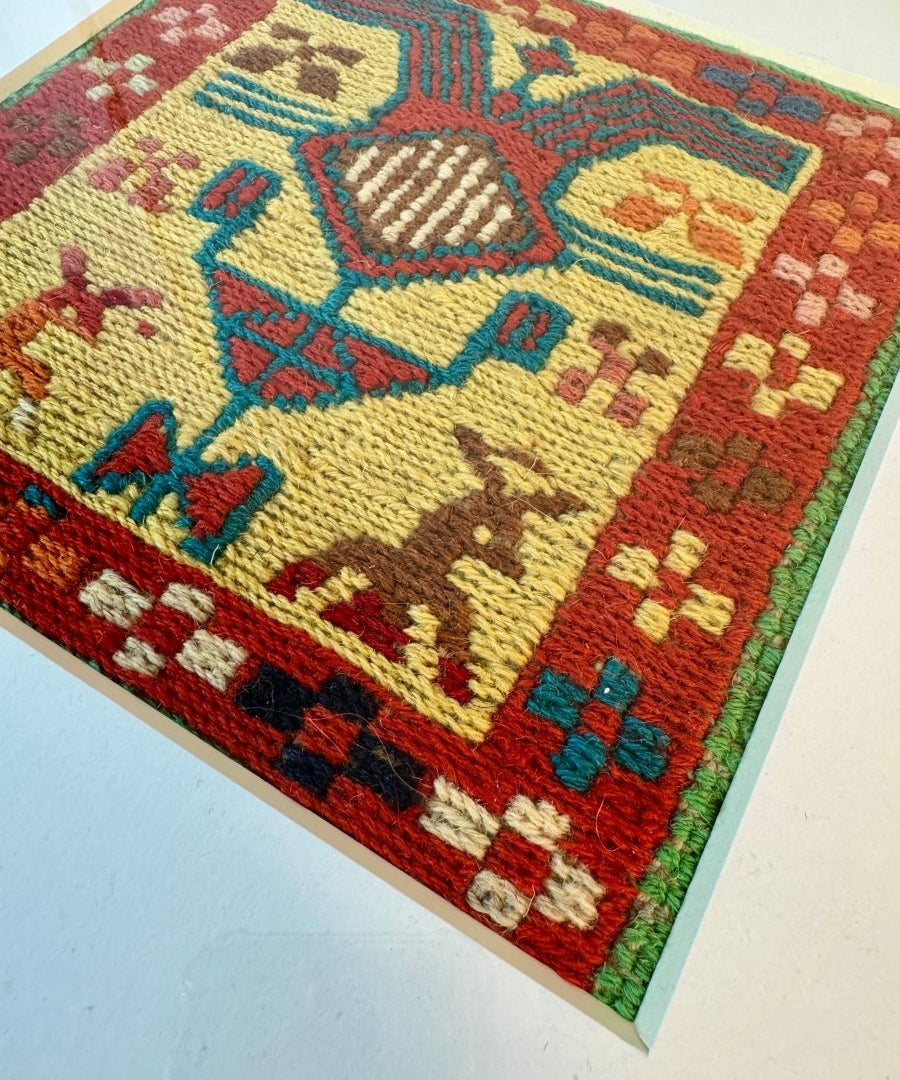 Handwoven kilim rug with red field, beige motifs, and teal blue border pattern.