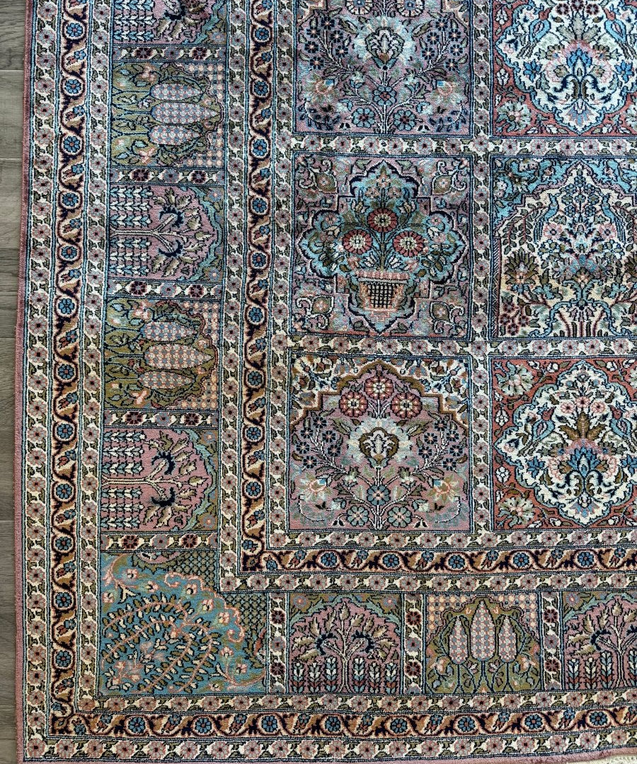 Patchwork-pattern rug with teal, blue, and cream motifs plus dark border edging.