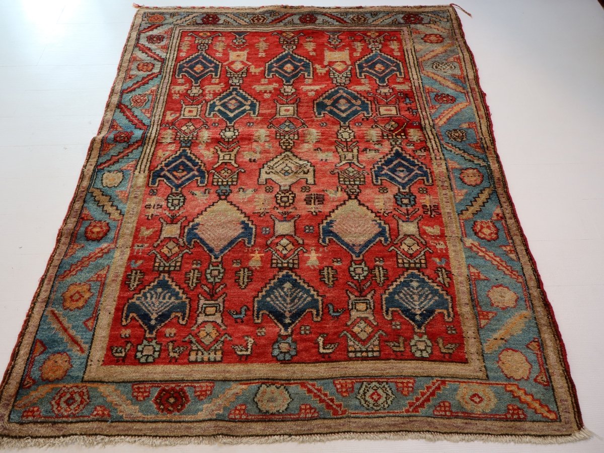 Patterned rug with red center, blue side panels, and cream-and-navy repeating motifs