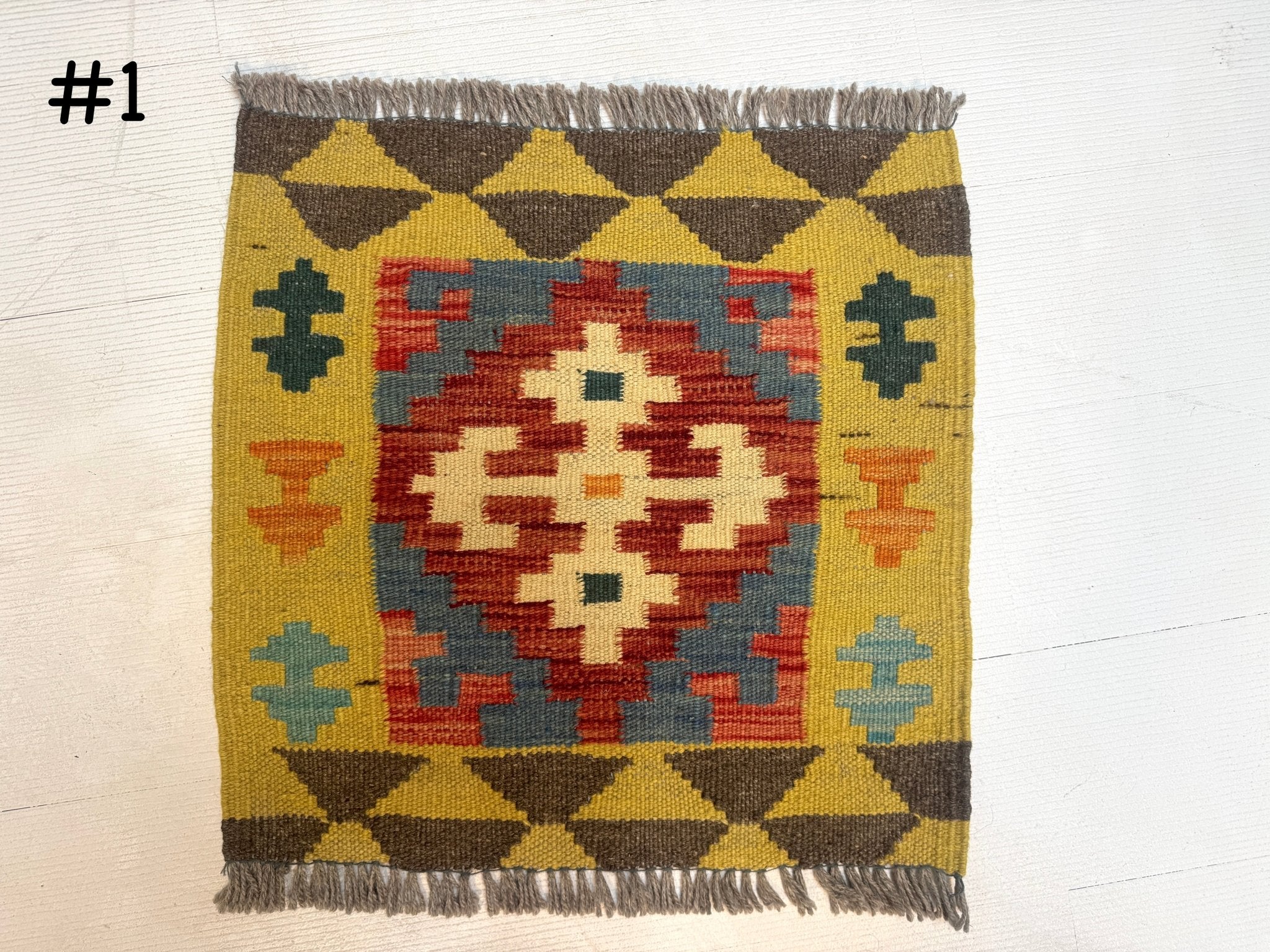 Mini Afghan kilim rug with brown fringe, geometric medallion in red, yellow, and green