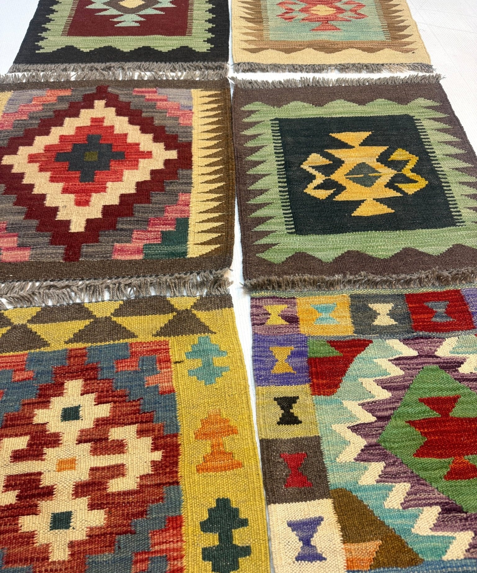 Mini Afghan kilim rug close-up of geometric squares in green, red, tan, black