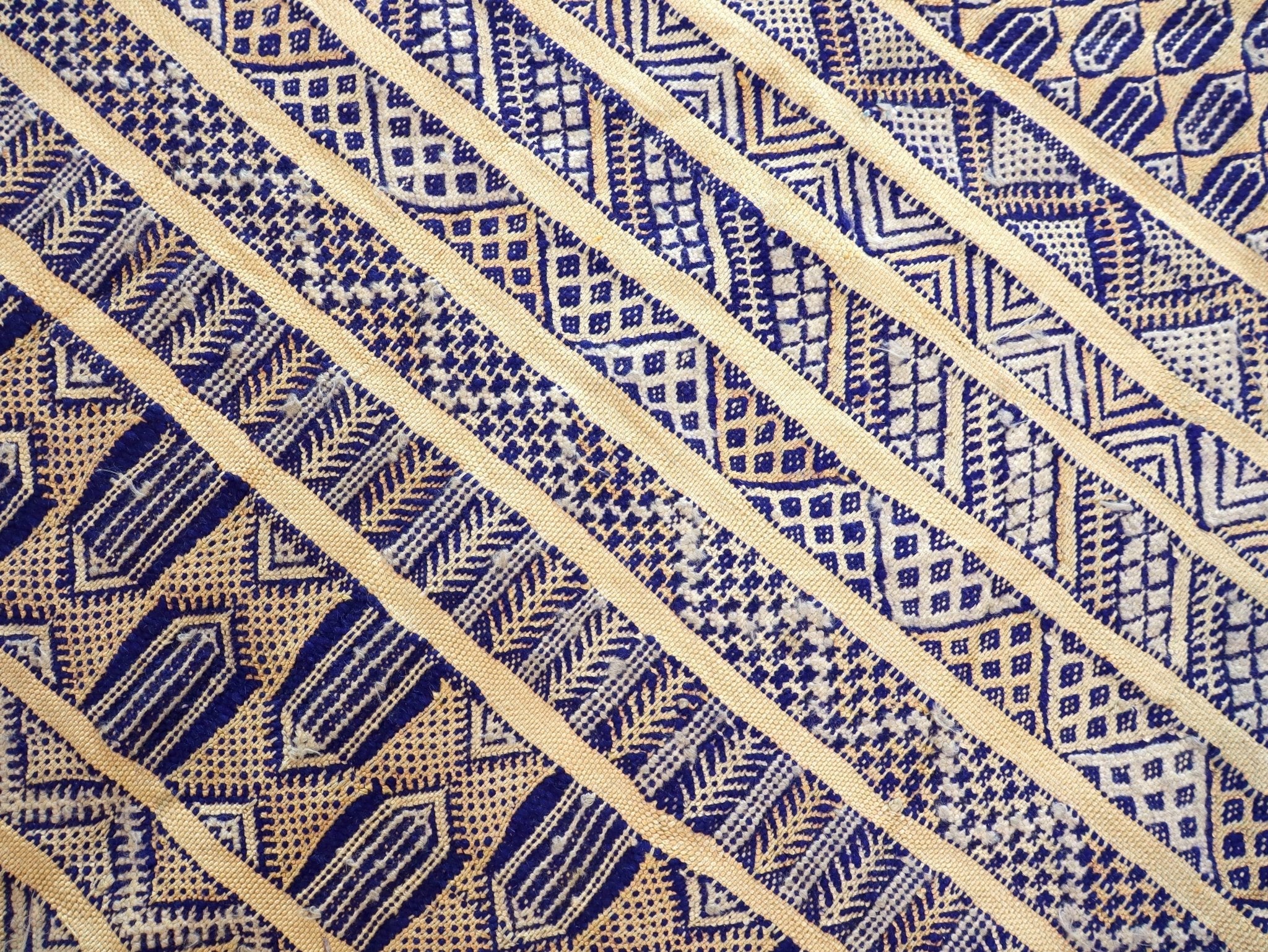 Close-up kilim rug showing diagonal stripes in blue and cream geometric weave