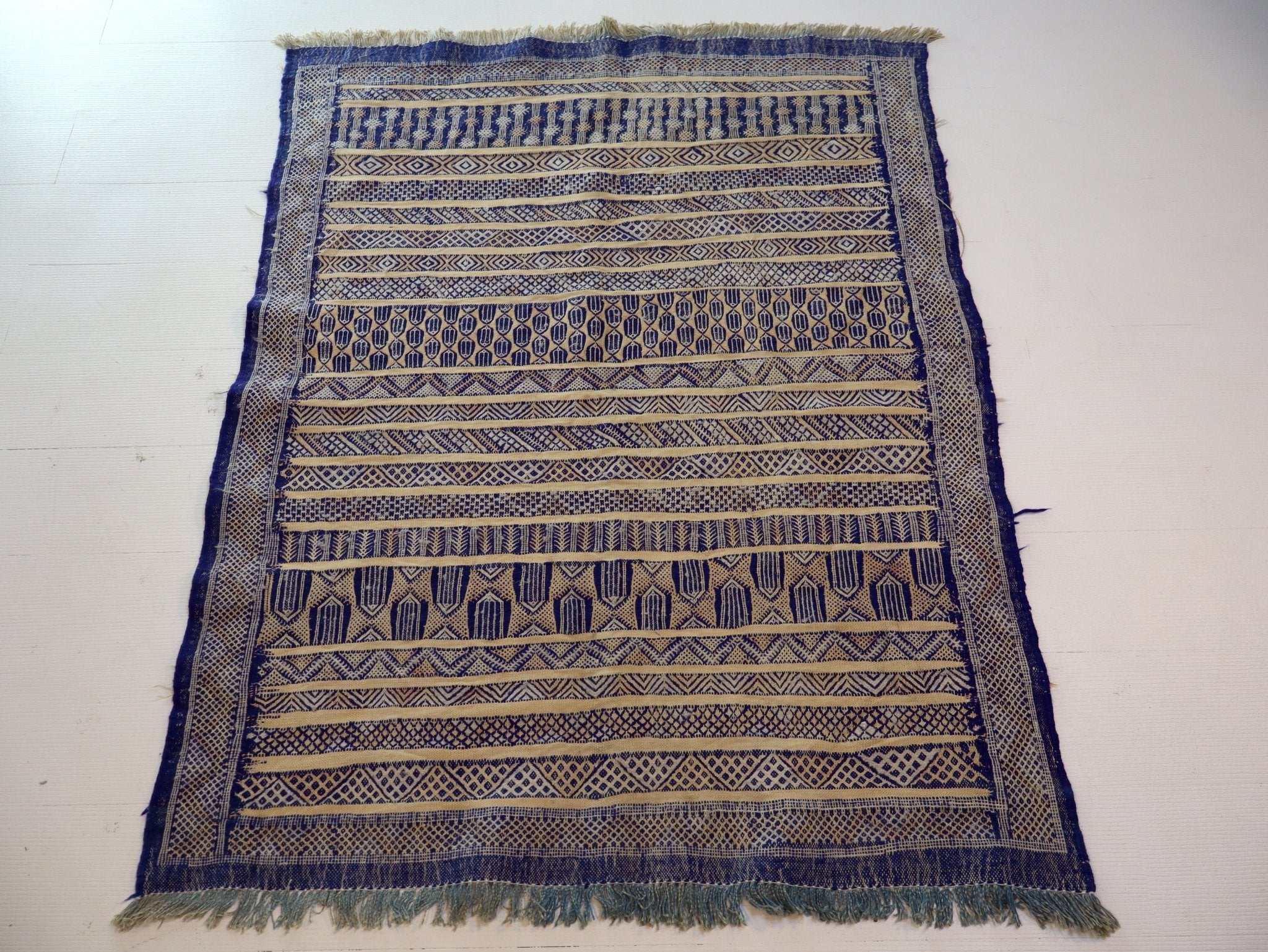 Blue and cream kilim rug with striped geometric motifs and fringe border