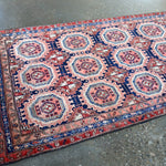 Persian runner rug wide view with navy border and red medallion pattern