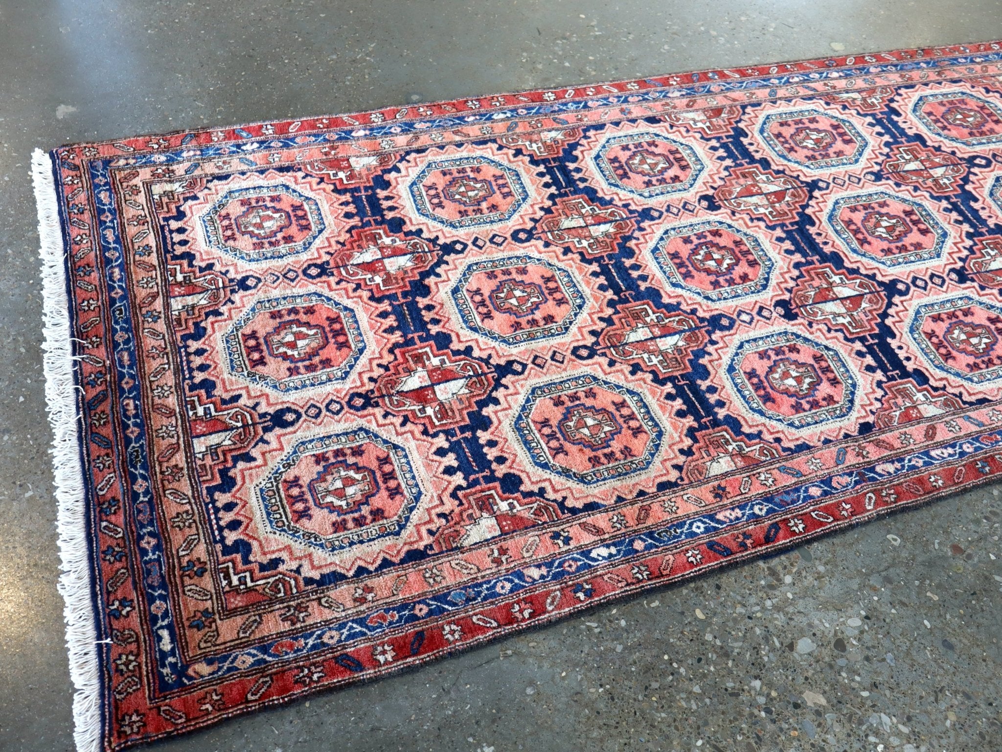 Persian runner rug wide view with navy border and red medallion pattern