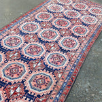 Persian-style runner rug detail showing red and navy medallions on a cream field