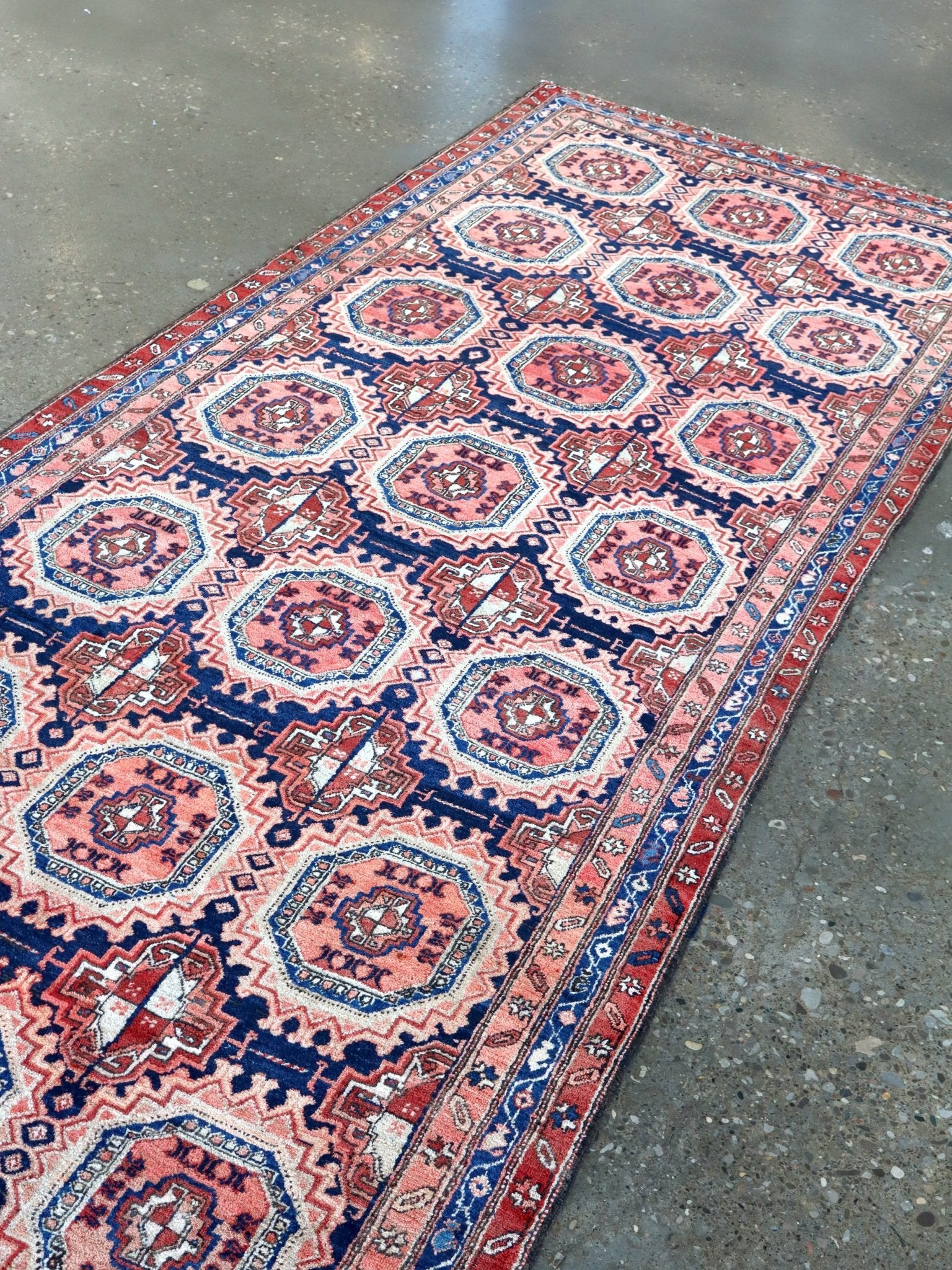 Persian-style runner rug detail showing red and navy medallions on a cream field